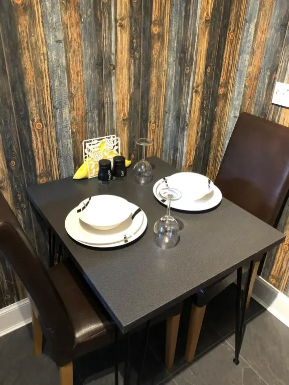 a black table with two white plates on it at Thistle Apartment, Inverness in Inverness