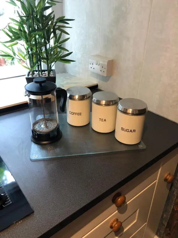 a kitchen counter with three coffee pots on a shelf at Thistle Apartment, Inverness in Inverness