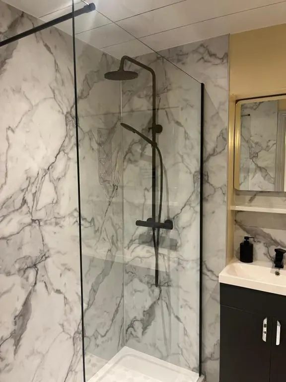 a bathroom with a shower with a glass at Bishops Park Apartment in Inverness
