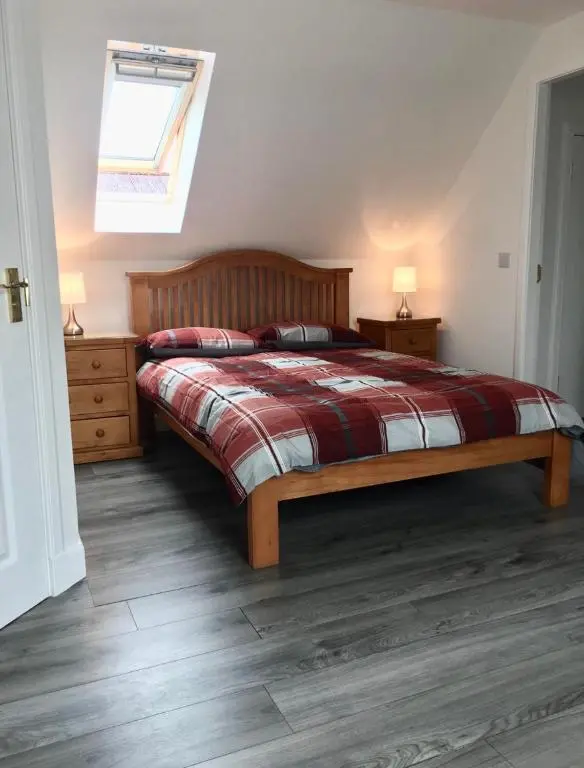 a bedroom with a bed and two night stands and a window at Kilberry Guest House in Beauly