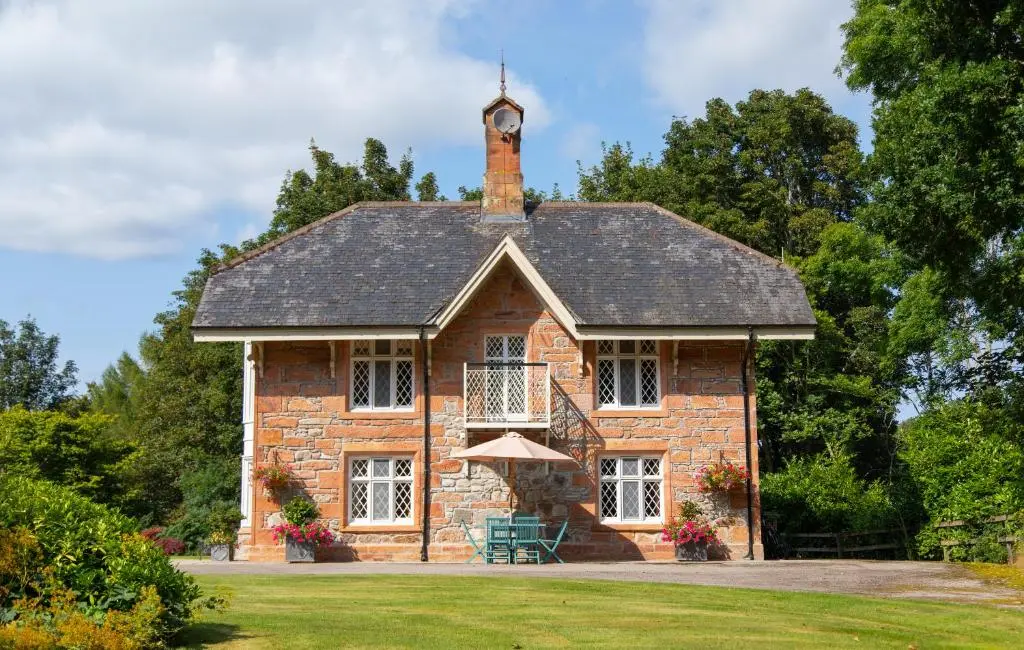 a brick building with a clock tower on top of it at Balnagown Estates Swiss Cottage in Barbaraville