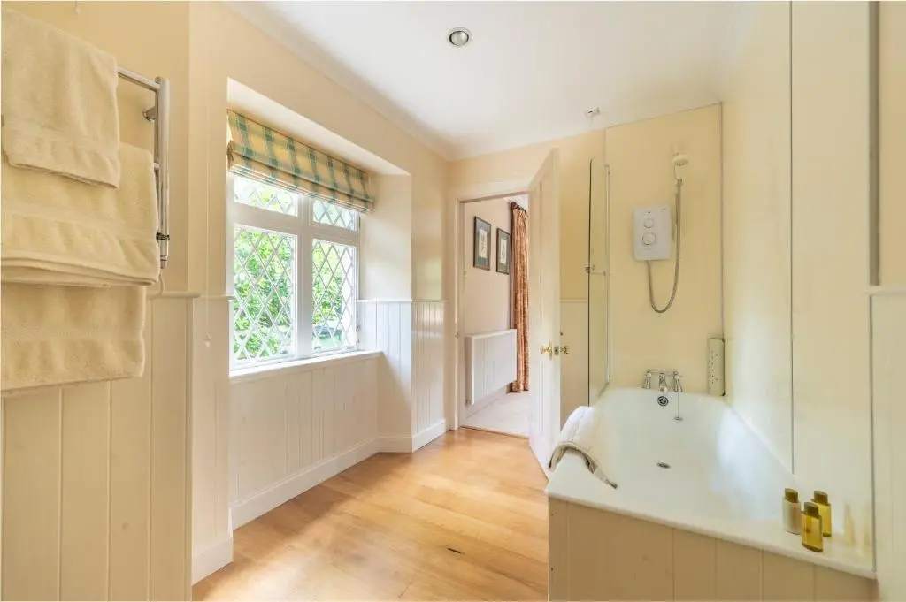 a white bathroom with a tub and a window at Balnagown Estates Swiss Cottage in Barbaraville