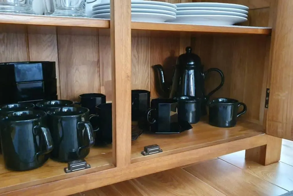 a bunch of black coffee pots and pans on a shelf at Smart & Stylish Holiday Apartment in the city centre in Inverness