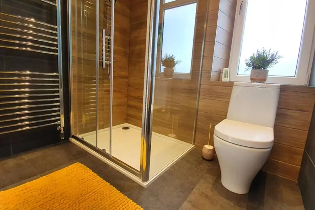 a bathroom with a shower and a toilet with a glass door at Smart & Stylish Holiday Apartment in the city centre in Inverness