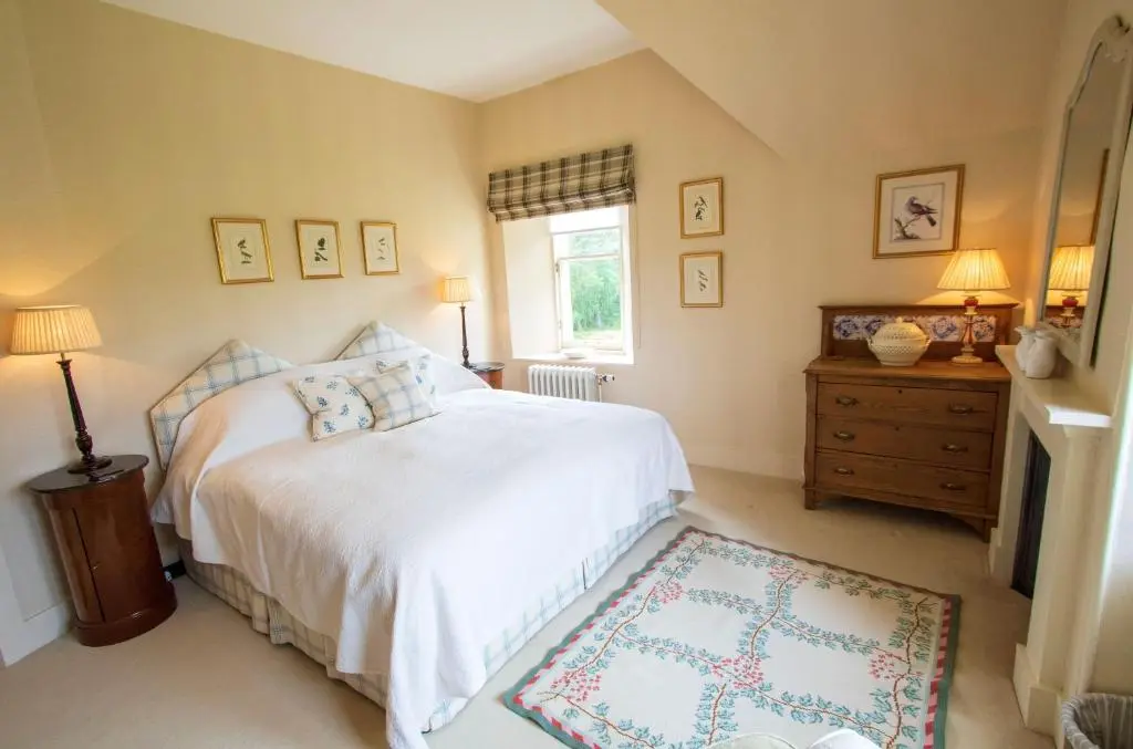 a bedroom with a white bed and a window at Inveroykel Lodge at Rosehall in Rosehall