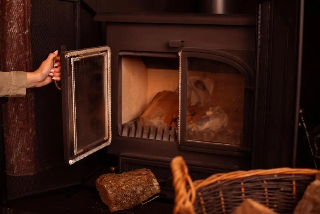 a person standing in front of a fireplace at Inveroykel Lodge at Rosehall in Rosehall