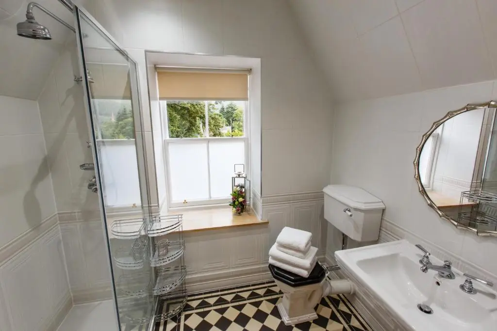 a bathroom with a shower and a toilet and a sink at St Andrews House in Ballater