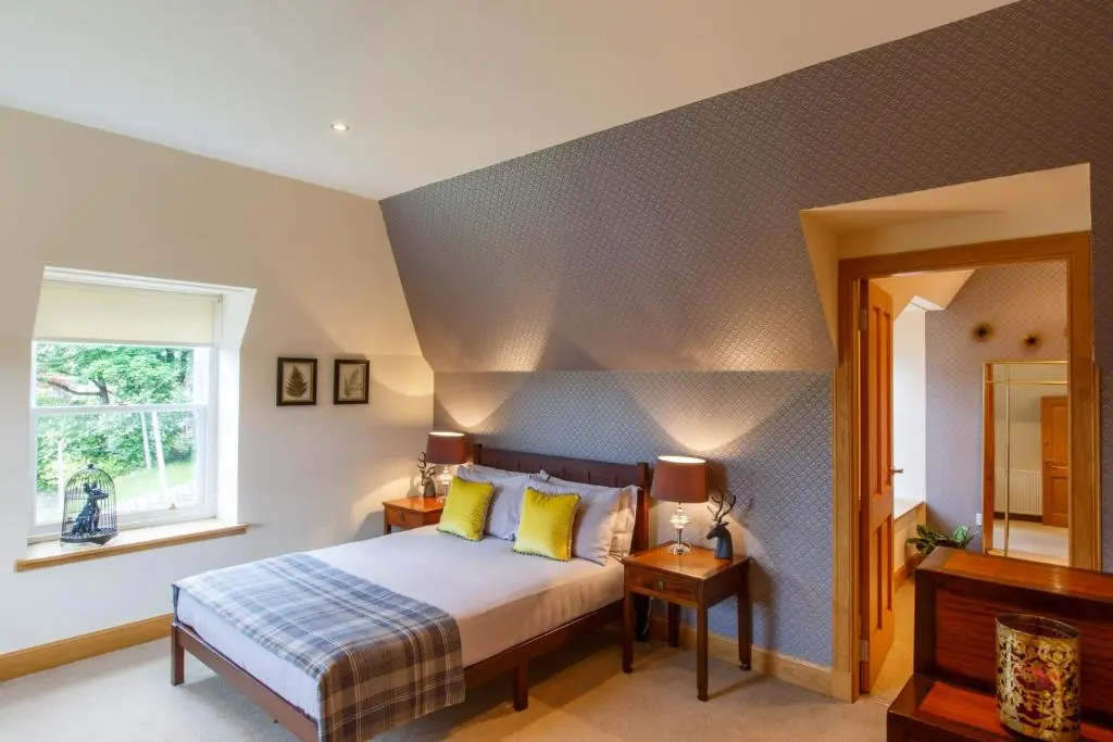 a bedroom with a bed and a window at St Andrews House in Ballater