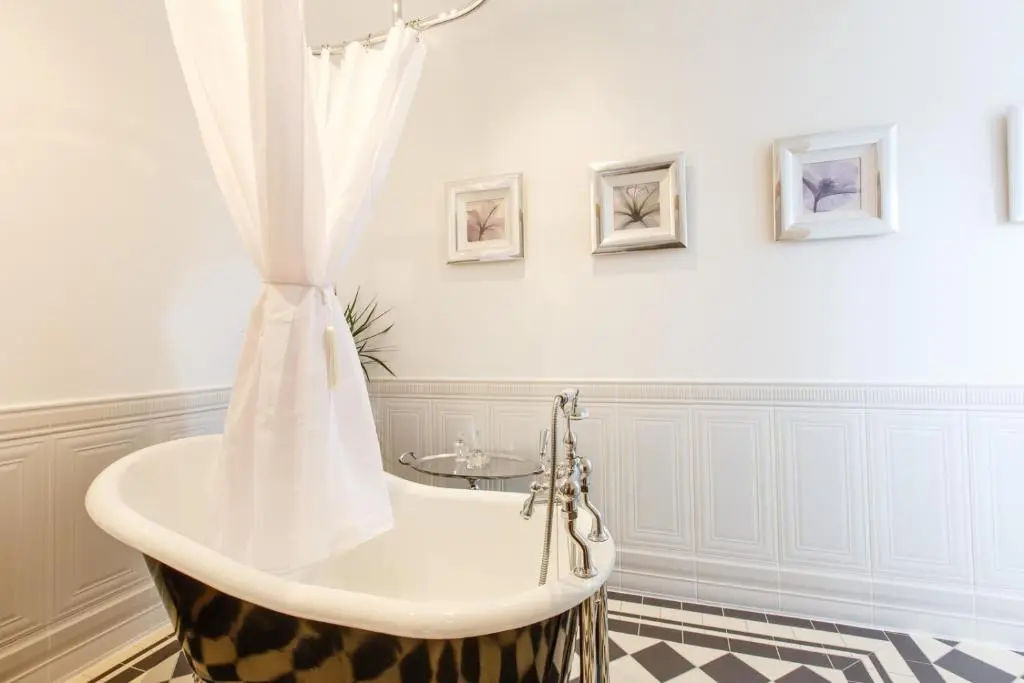 a bathroom with a bath tub with a shower curtain at St Andrews House in Ballater