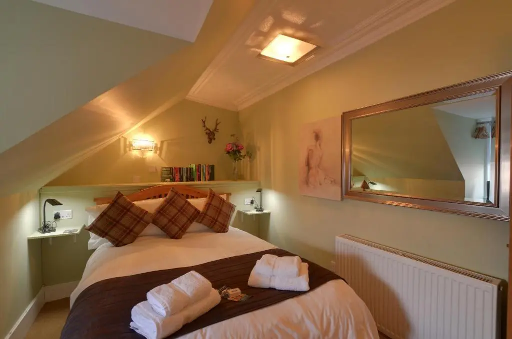 a bedroom with a bed with two towels on it at King Street Apartment in Inverness
