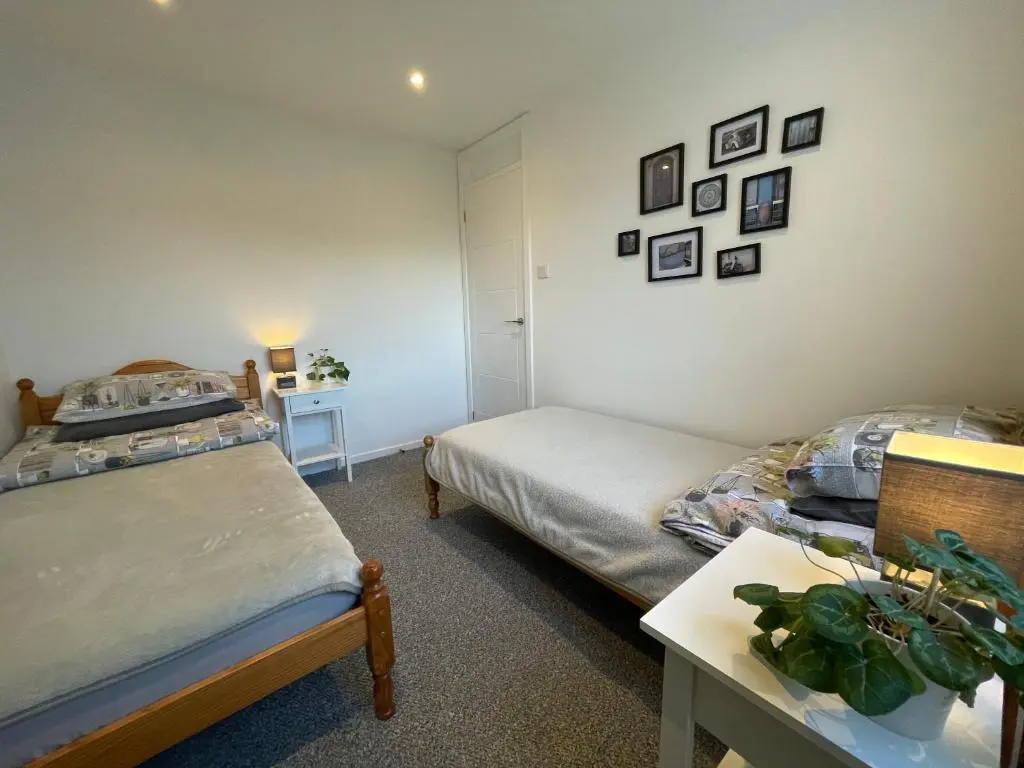 a room with two beds and a table in a room at Blarmore Apartment Inverness in Inverness