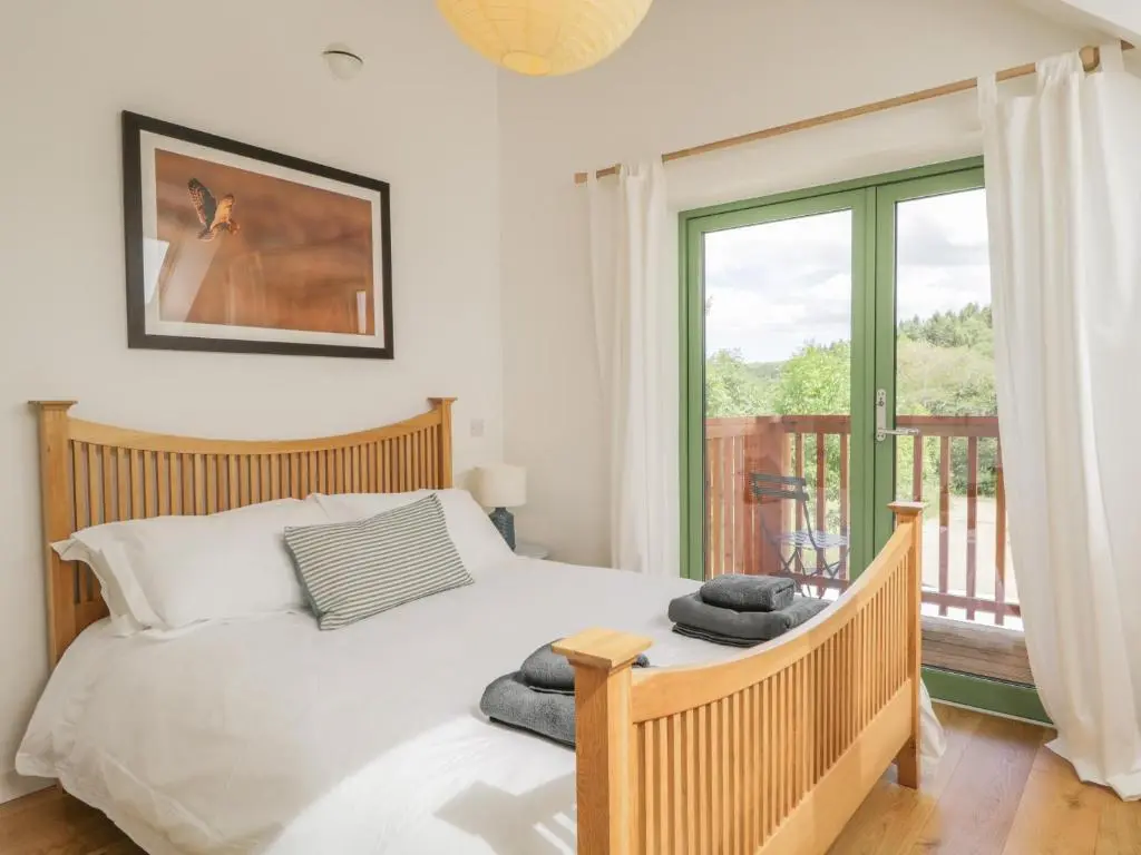 a bedroom with a bed and a balcony at Na Clamhanan in Forres