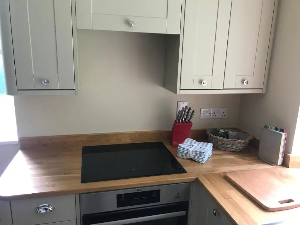 a kitchen with white cabinets and a counter top at North Lodge in Invergarry