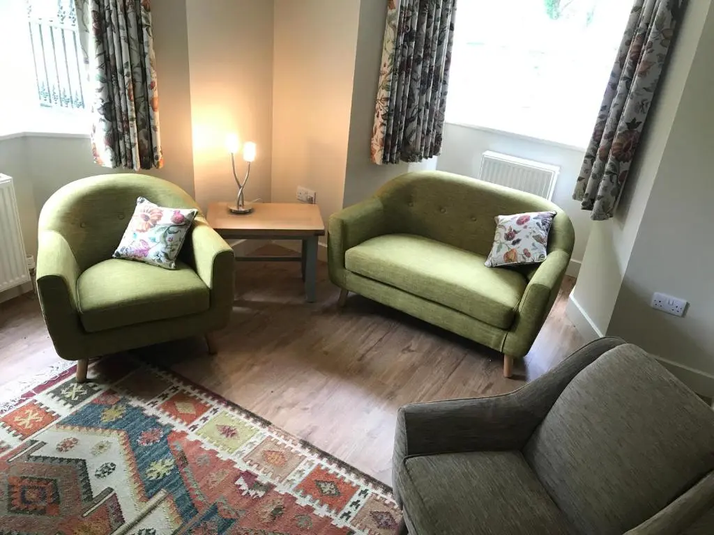 a living room with two chairs and a table at North Lodge in Invergarry