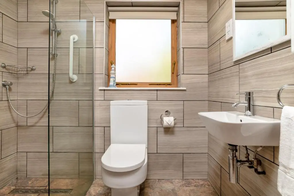 a bathroom with a toilet and a sink at Dormie Cottage, lovely bright and spacious bungalow with wood fire in Ballater
