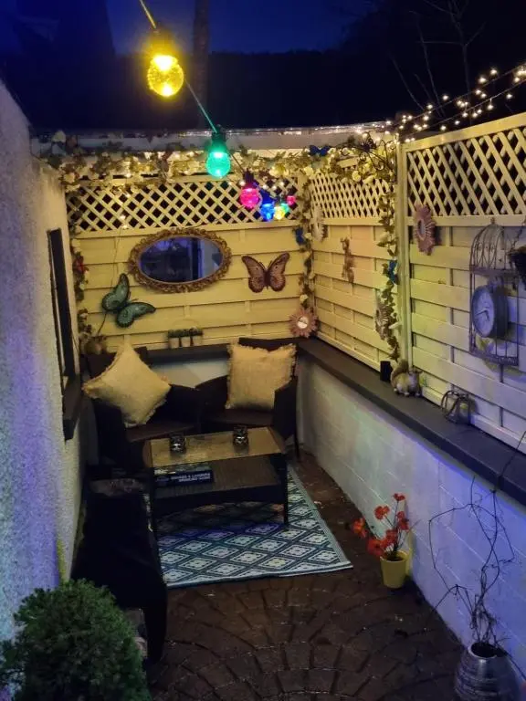 a small balcony with a couch and butterfly decorations at The little garden hoose in Inverness