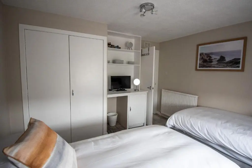 a bedroom with a bed and a white cabinet at The View 3-Bed Cottage Findochty Buckie Moray in Findochty