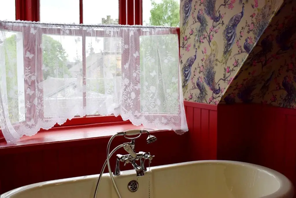 a bathroom with a white tub and a window at The Mash Tun in Aberlour