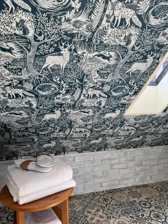 a bathroom with a blue and white wallpaper at The Mash Tun in Aberlour