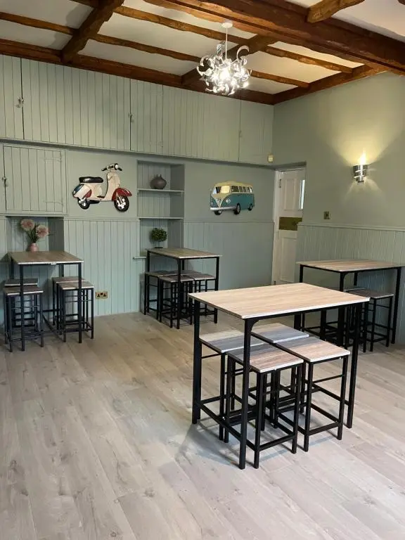 a room with tables and chairs and a scooter on the wall at The Banks Of Ury in Inverurie