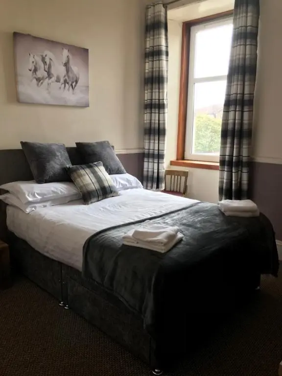 a bedroom with a large bed with a window at The Banks Of Ury in Inverurie