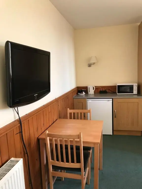 a room with a table and a television on a wall at The Banks Of Ury in Inverurie
