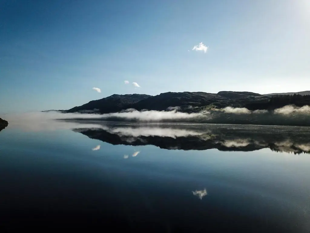 a body of water with a mountain in the background at Cabins at Old Pier House in Fort Augustus