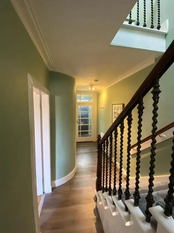 a staircase in a home with green walls at No. 20 in Inverness