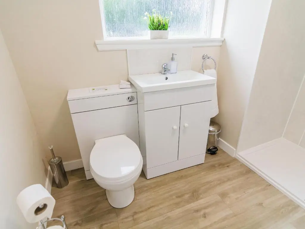 a bathroom with a toilet and a sink and a window at Keepers Cottage - Uk30246 in Cray