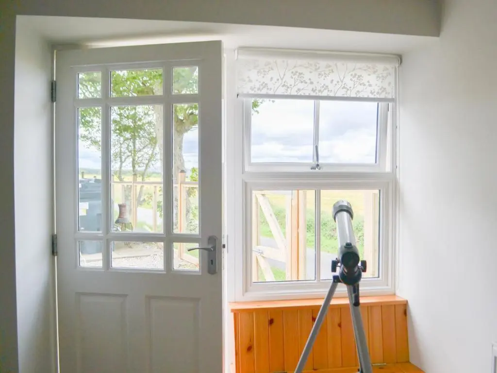 a tripod in front of a door with a camera at Mansefield Cottage in Boyndie