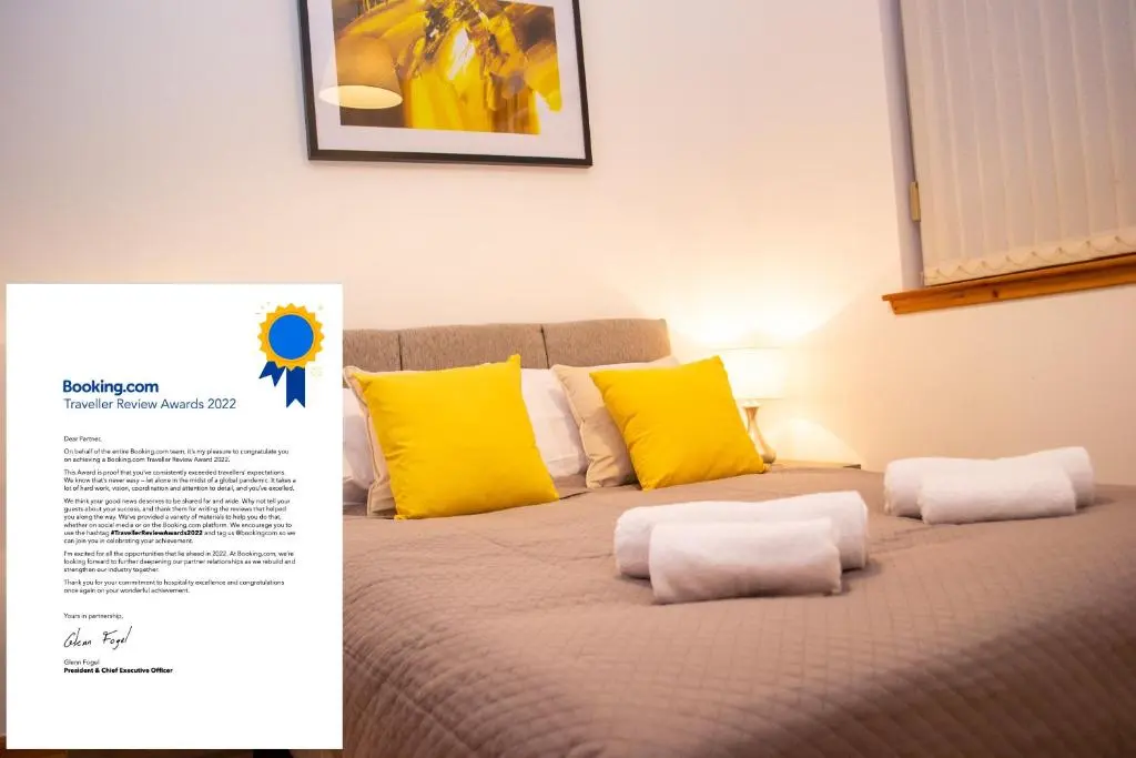 a bed with yellow and white pillows and a poster at Superb 2 Bedroom Flat - Refurbished Dec 2024 in Inverness