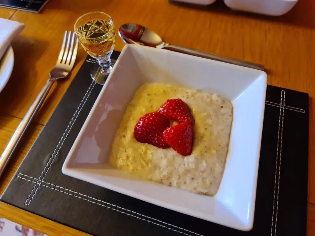 a bowl of rice with strawberries on top on a table at Bluebell House in Inverness