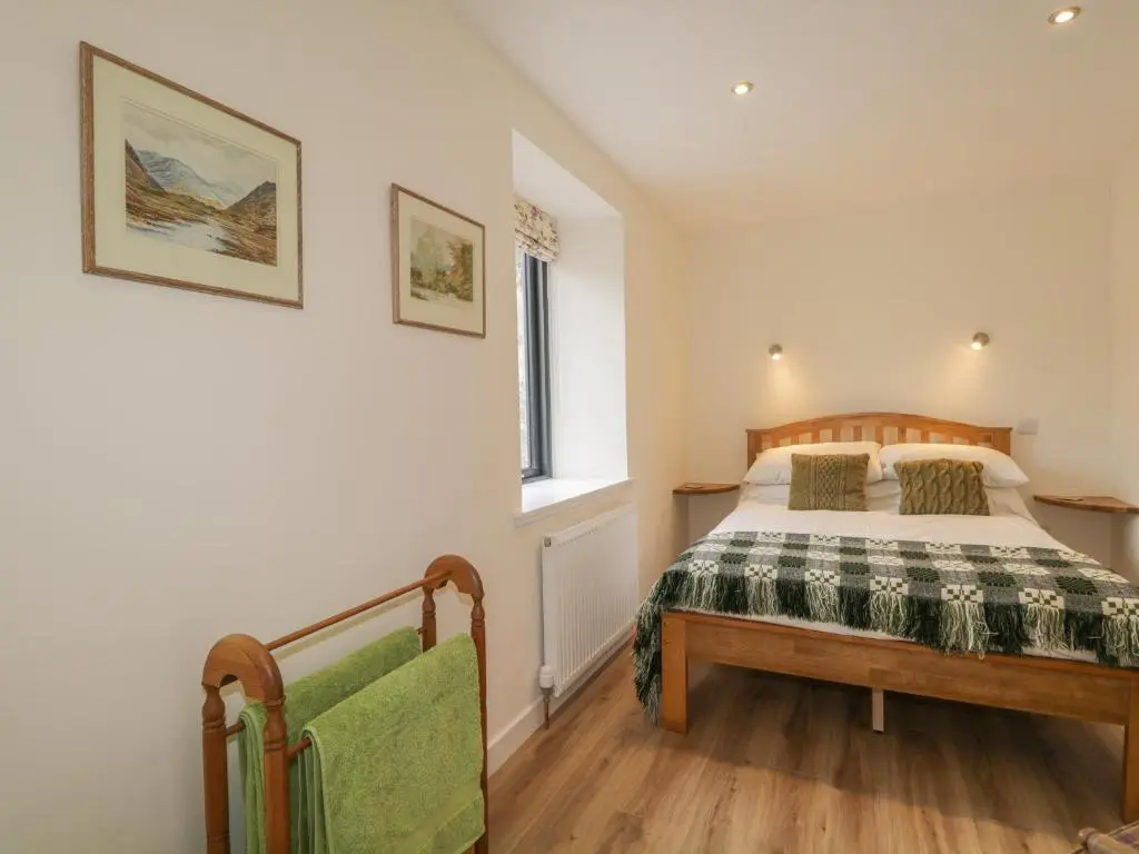 a bedroom with a bed and a window at Enzie Station Cottage in Buckie
