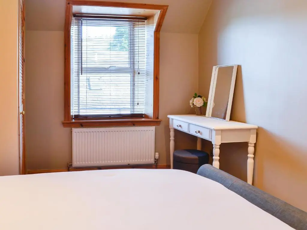a bedroom with a bed and a desk and a window at East Lewiston in Drumnadrochit