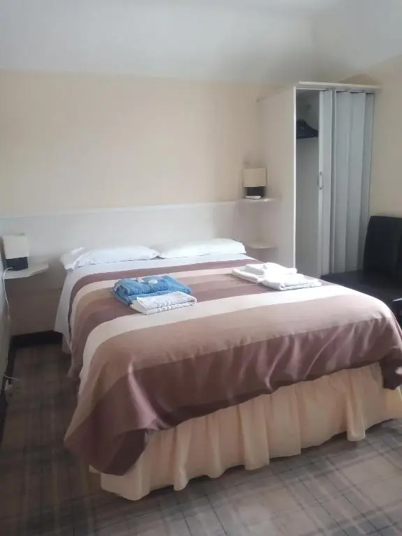 a bedroom with a large bed with two towels on it at BELLEVILLE BED AND BREAKFAST in Elgin