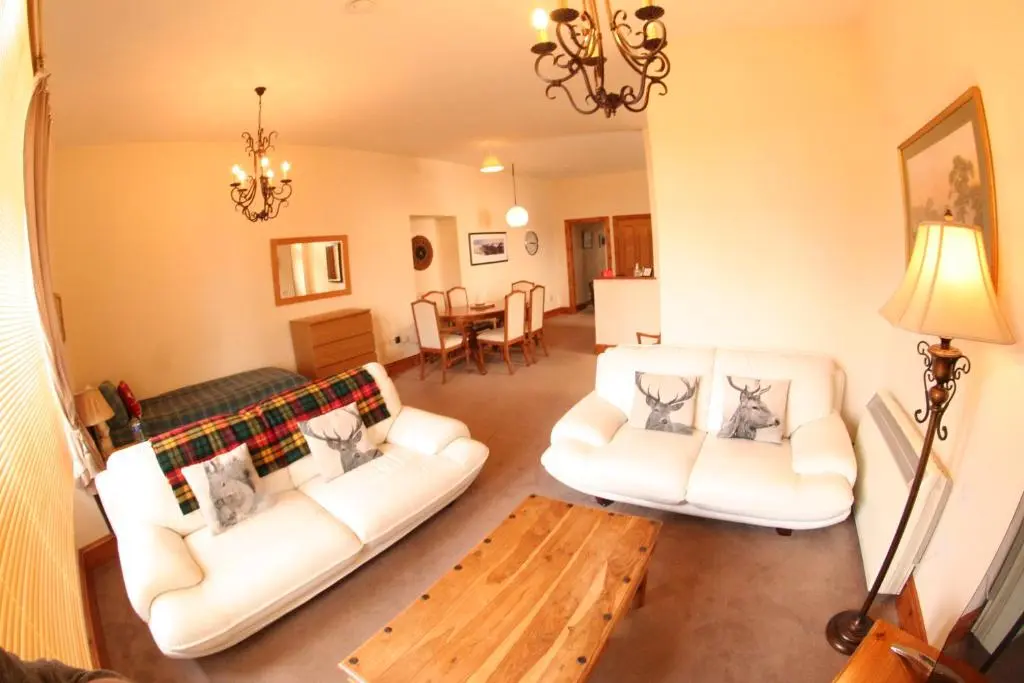 a living room with two white couches and a table at Dalmore in Nairn