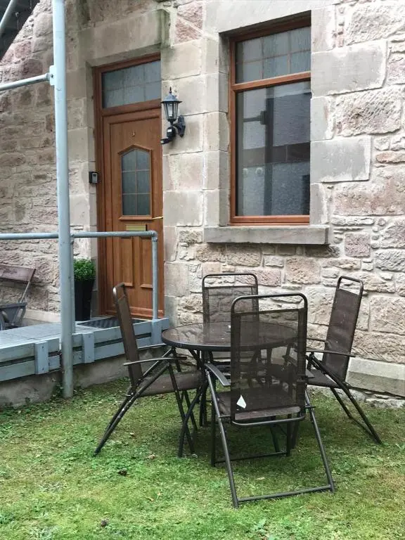 a table and chairs in front of a building at Dalmore in Nairn