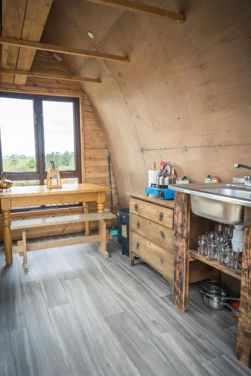 a kitchen with a sink and a table in a room at Shepherd's Loch Glamping in Turriff