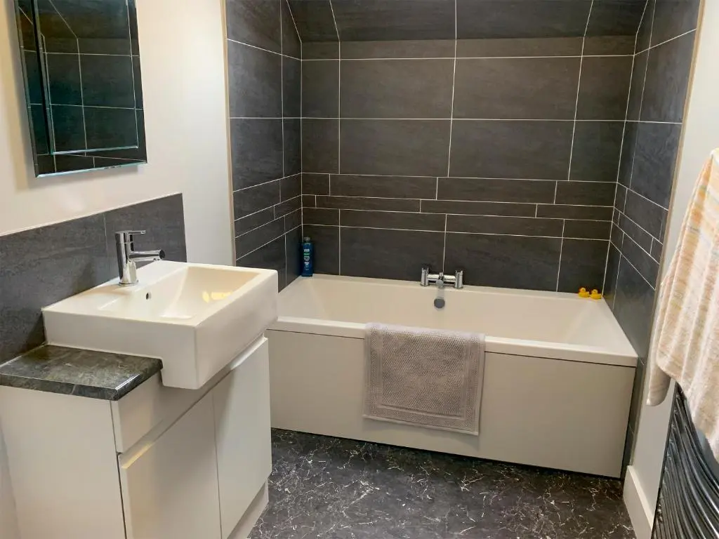 a bathroom with a white tub and a sink at The Coyles - Uk31466 in Ballater