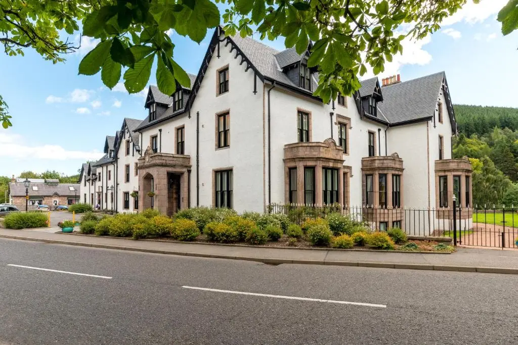 a large white house on the side of a street at Historic Village, Rare Find, Amazing Views in Ballater