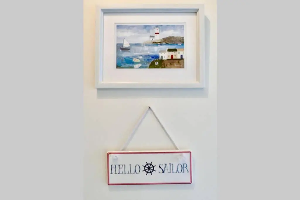 a sign hanging on a wall with a picture at St Brendans Apartment in Elgin