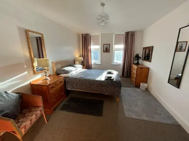 a bedroom with a bed and a couch at Centrally located 2 bed modern flat with harbour views in Wick