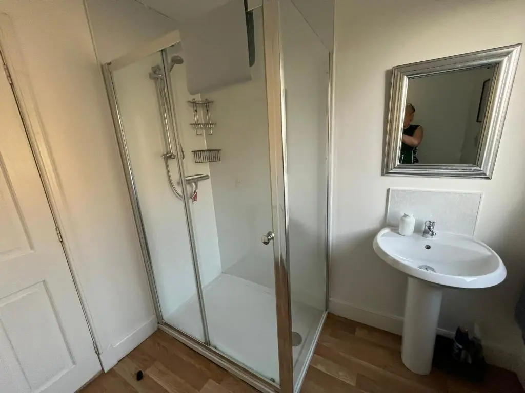a bathroom with a shower and a sink at Centrally located 2 bed modern flat with harbour views in Wick