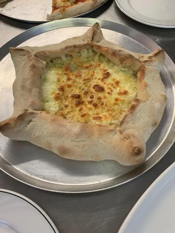 a pizza sitting on a plate on a table at The Aberdeen Arms Hotel in Tarves