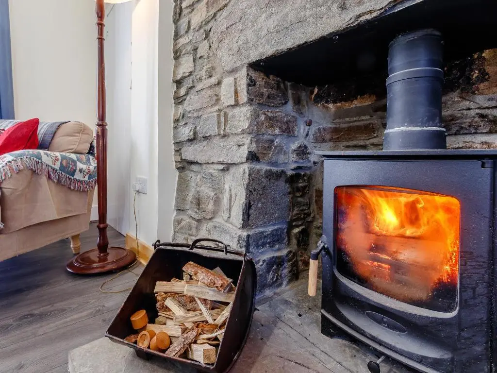 a stone fireplace with a pan of food in front of it at 19 South Street in Grantown on Spey