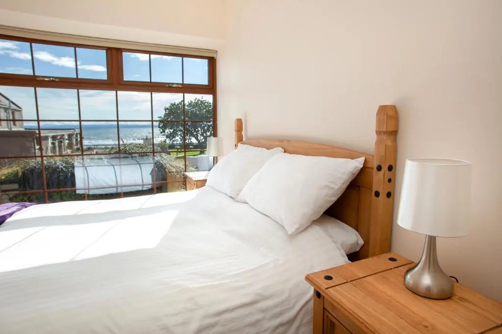 a bedroom with a white bed and a window at Balintore Inn in Balintore