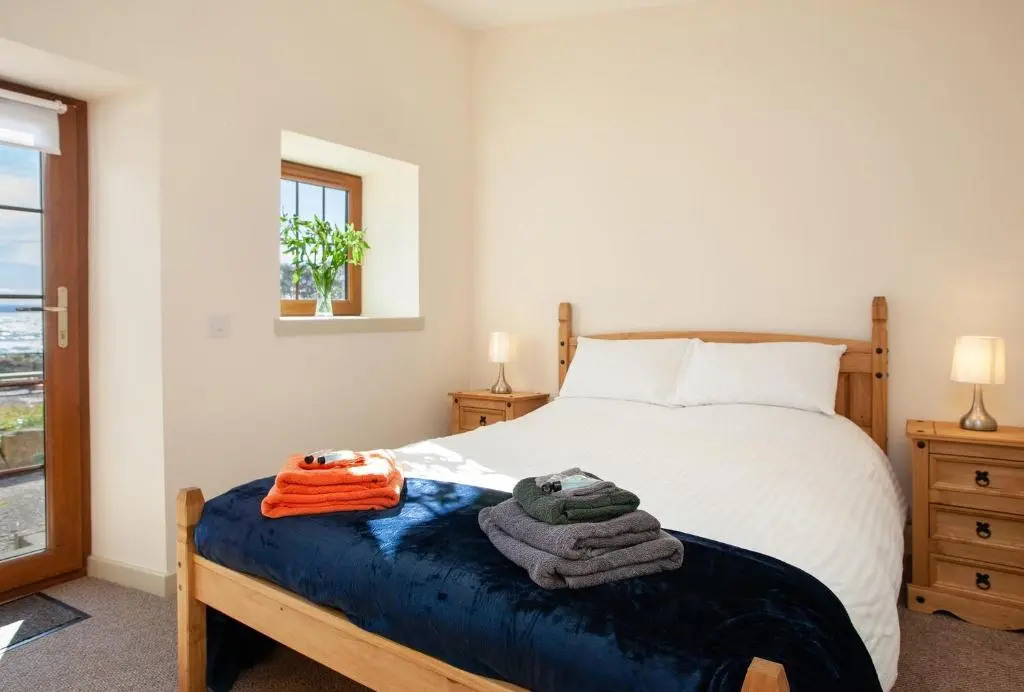 a bedroom with a bed with towels on it at Balintore Inn in Balintore