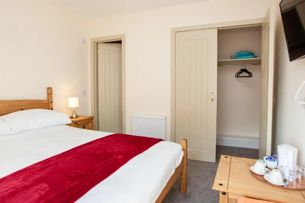 a bedroom with a bed and a table and a tv at Balintore Inn in Balintore