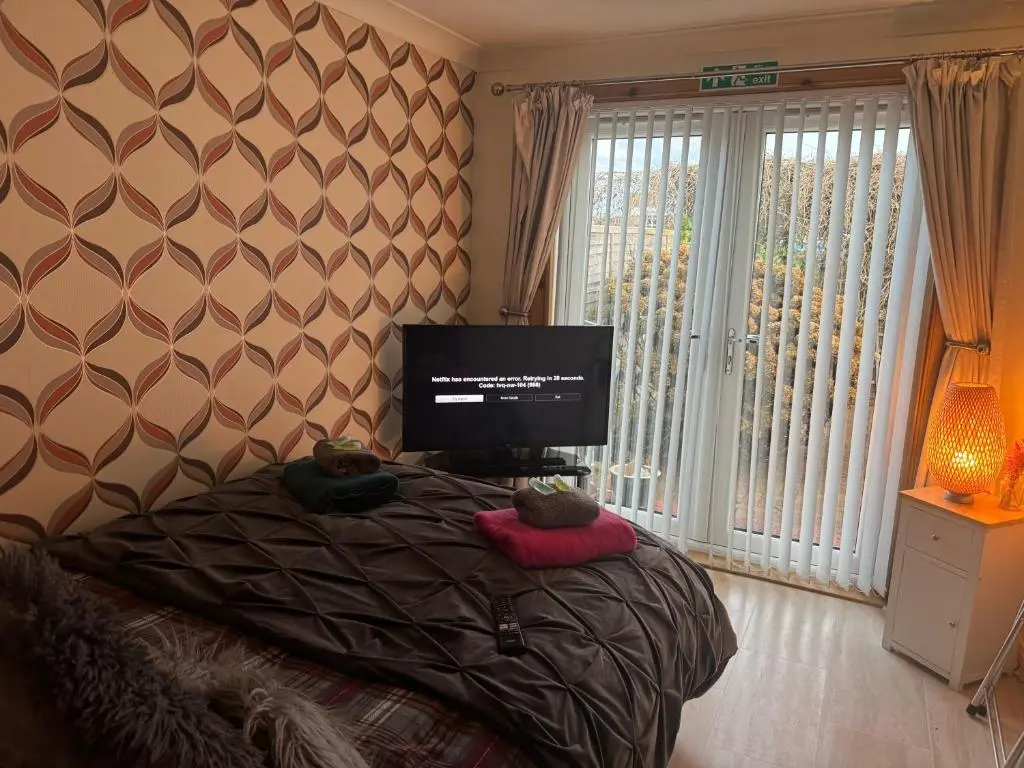 a bedroom with a bed with a flat screen tv at 3Bed House - Family Friendly - Close To LochNess in Inverness