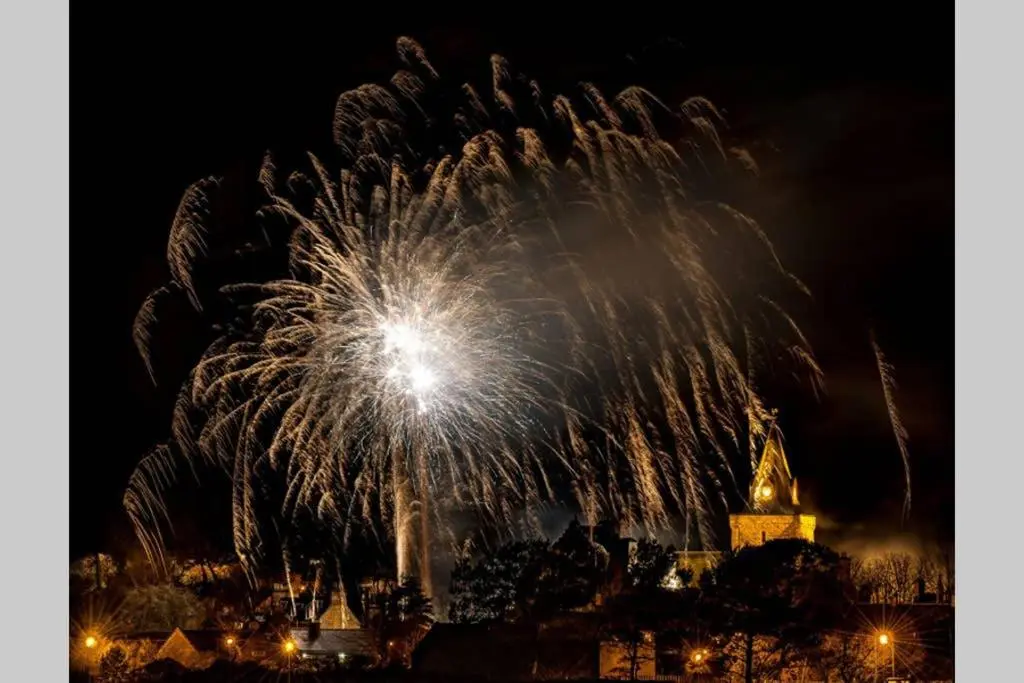 a firework display in front of a city at night at Highfield House in Dornoch